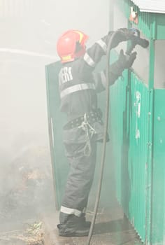 Firefighter in action - Fireman extinguishing a fire