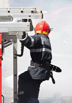 Firefighter in action - Fireman extinguishing a fire
