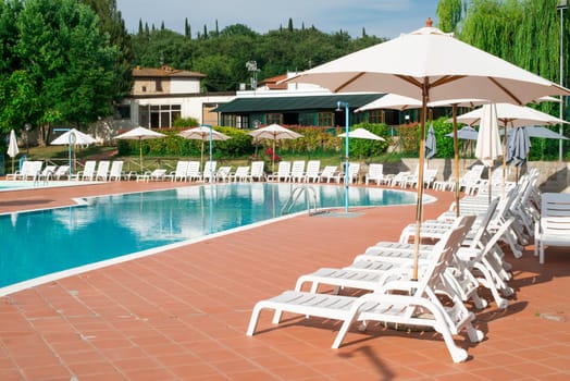 Pool and white sun loungers. Rounded shapes pool