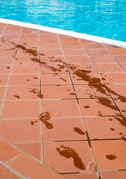 Footprints of bare feet to swimming pool. Water footprints