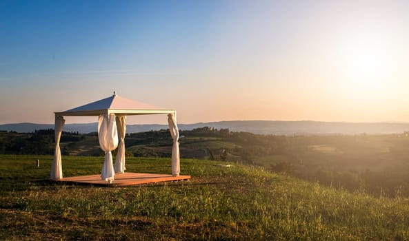 White gazebo in a mountain. Sun lights.
