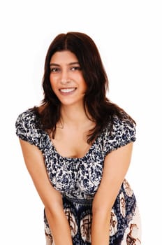 A beautiful brunette woman bending forwards, standing in a.nice dress, isolated for white background..