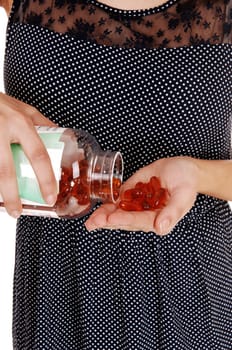 A closeup picture of the body of a young woman holding a bottle with.vitamin capsule, isolated on white background..