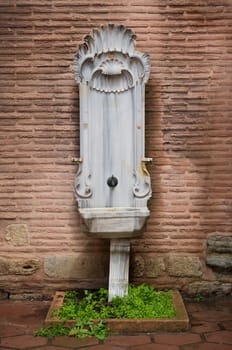 beautiful marble fountain against a brick wall