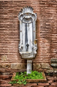 vintage marble fountain against a brick wall