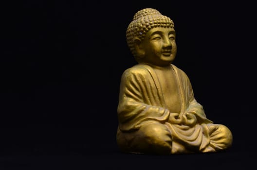 Golden Buddha Statue on a Black Background