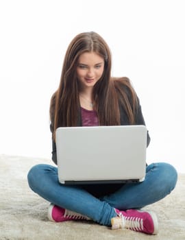 Mädchgen sits on the laptop