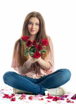 Girl sits amid rose petals