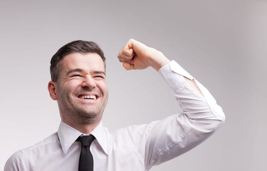 a winning man exulting and raising up his arm and fist because he is a successful one