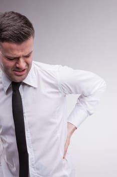 a man massaging his back because of his severe pain on his back