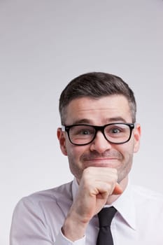 a nerdy man with a good idea in mind with glasses and smiling at camera