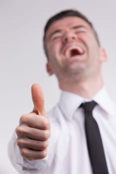 this man shows a thumbs up sign while he smiles cheerful because he probably strongs agrees or likes what's going on