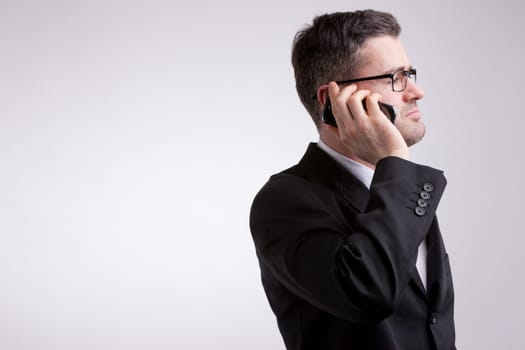 an elegant businesman listening to his mobile phone while watching somewhere in the future