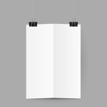 White sheet of paper folded in half. The paper hangs on black binder clips.