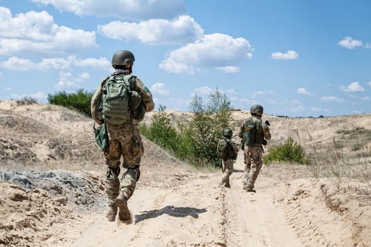 Squad of soldiers patrolling across the desert