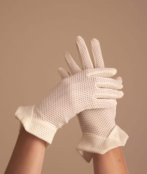 A woman's hands and forearms are shown as she models a vintage pair of formal mesh white gloves with unique cuff. Her hands are crossed over each other.