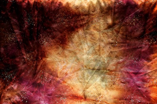 A colorful hand dyed mottled fabric in shades of red, yellow, orange, pink and purple fills the image.