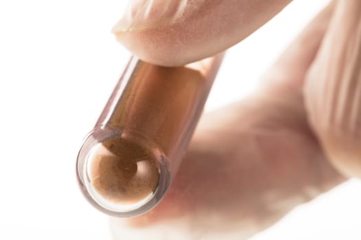 Brown powder substance in test tube for analysis