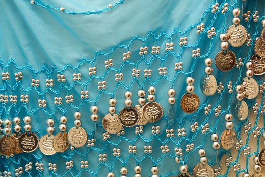 A blue antique belly dancer's skirt showing silvery beads and charms.