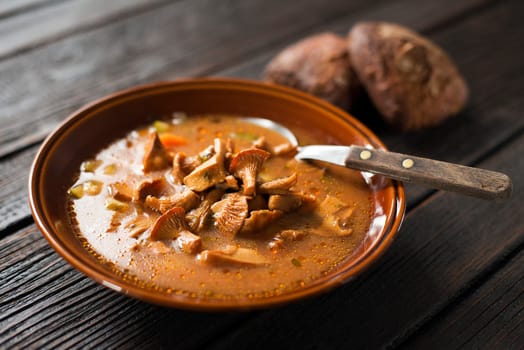 Fresh mushroom soup on wooden background close up