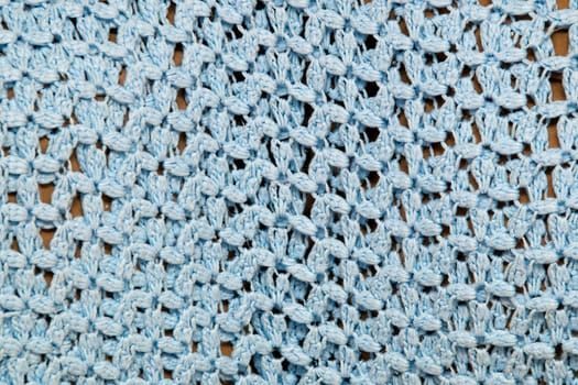 A large blue crocheted afghan blanket fills the frame of this image making it suitable for knitting background.