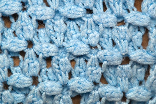 A detailed close up of blue crocheted afghan blanket fills the frame of this image making it suitable for knitting background.