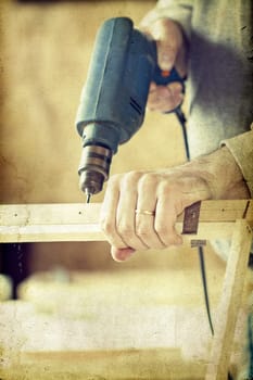 Man's arms drill lath in the workshop - vintage photo