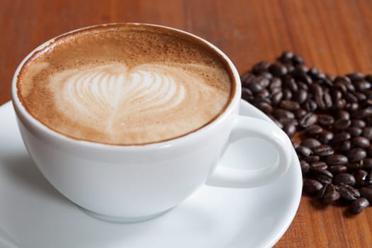 Coffee cup and beans on a wood table