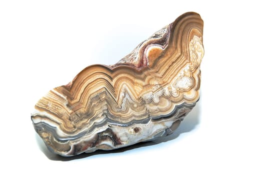 A layers and colorful cut and polished stone over white showing the various designs within. Over white.