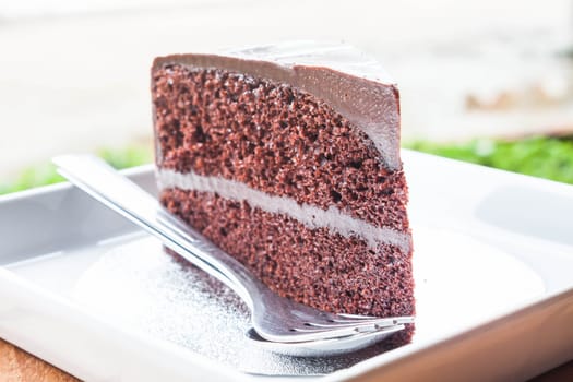 Close up chocolate custard cake serving with spoon and fork