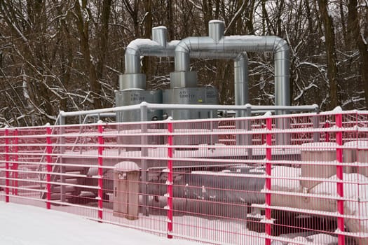 Community heating pipeline in wintertime having a lot of snow and ice. Good contrast of the snow and the red fence.