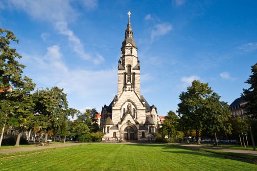View of the Michaeliskirche in Leipzig/Germany suurounded by a little park. The 70m high building shows architectonic elements of different styles.
