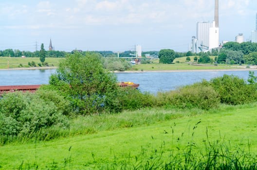 Beautiful Rhine landscape with a view of a power plant in a green environment.