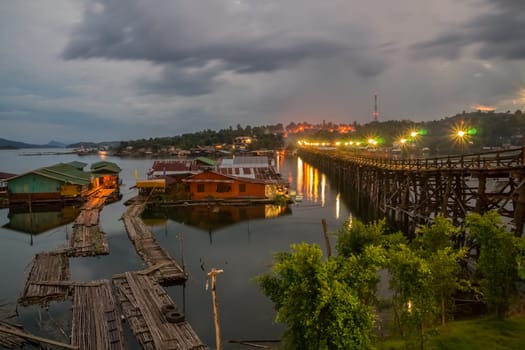 An evening view to the 400m long wooden Mon bridge over some floating houses in Songkhla Buri, a remote Thai town close to the burmese border.