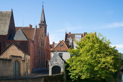 Impressions of brickwall houses and a small church along a small river in the Venice of the North, Bruges in Belgium