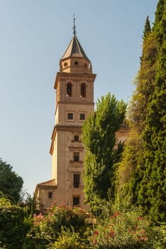 A tower at the well-known Alhambra in Granada/Spain surrounded by trees and flowers