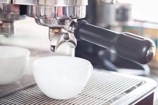 Prepares espresso in white coffee cup, stock photo