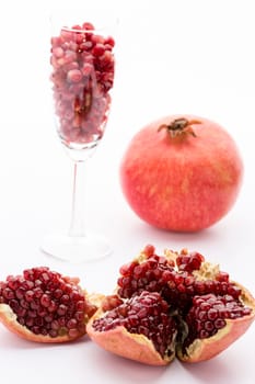 Cores of the pomegranate in the core housing. Pomegranate seeds in a champagne glass and a whole paradise apple.
