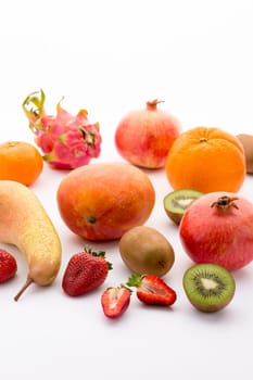 Various fruits,from southern fruit to tropical and exotic. Vitamin-rich and colourful. Kiwi and berry halved. Mango,orange,mandarin,pear,dragon fruit and pomegranate as a whole fruit.