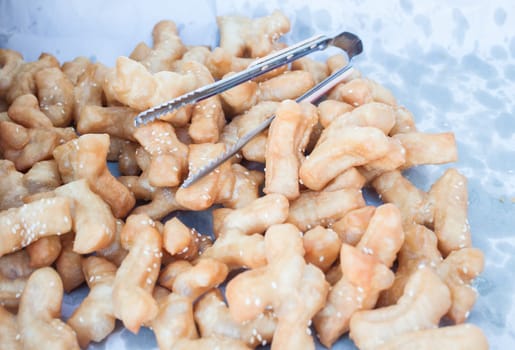 Deep fried dough stick with white sesame on paper
