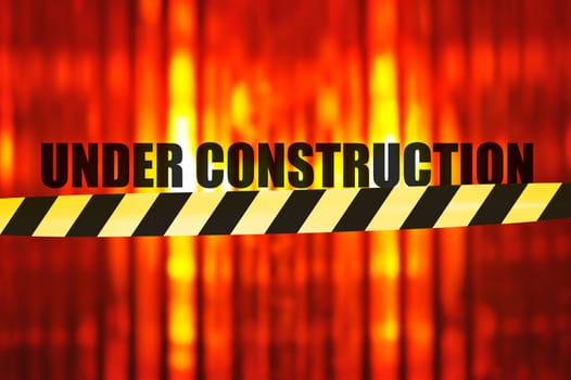 Construction site background with macro detail of an orange all-round light and shut-off tape