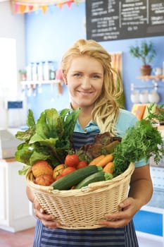 Woman Working In Shop With Basket Of Fresh Produce