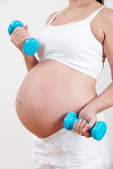 Close Up Of Pregnant Woman Exercising With Weights