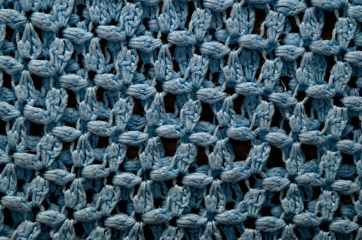 A large blue crocheted afghan blanket fills the frame of this image making it suitable for knitting background.