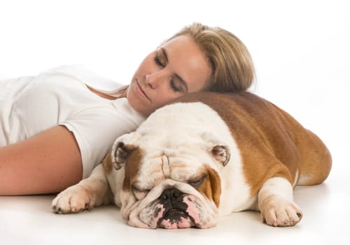 woman laying down with head resting on english bulldog