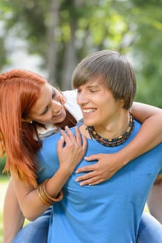 Loving couple piggyback hugging in sunny park enjoy first love