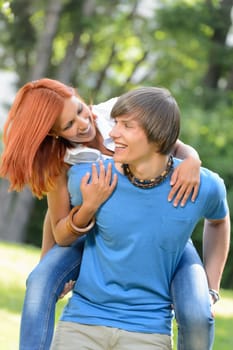 Man give piggyback ride to girlfriend park couple have fun