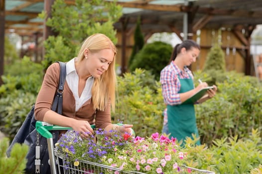 Young woman shopping cart for flowers at garden center smiling