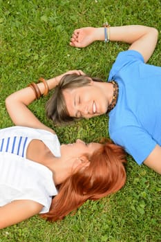 Romantic young couple lying on grass teenage love top view
