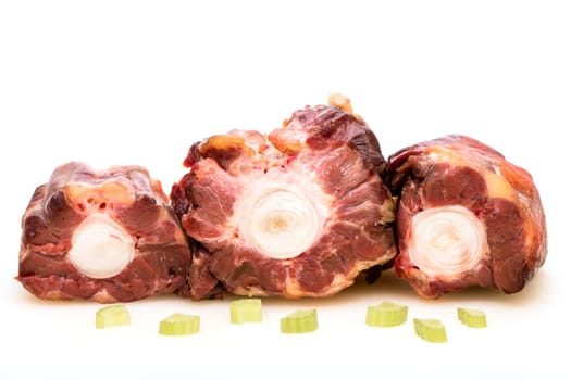 White insulated raw oxtail with celery
